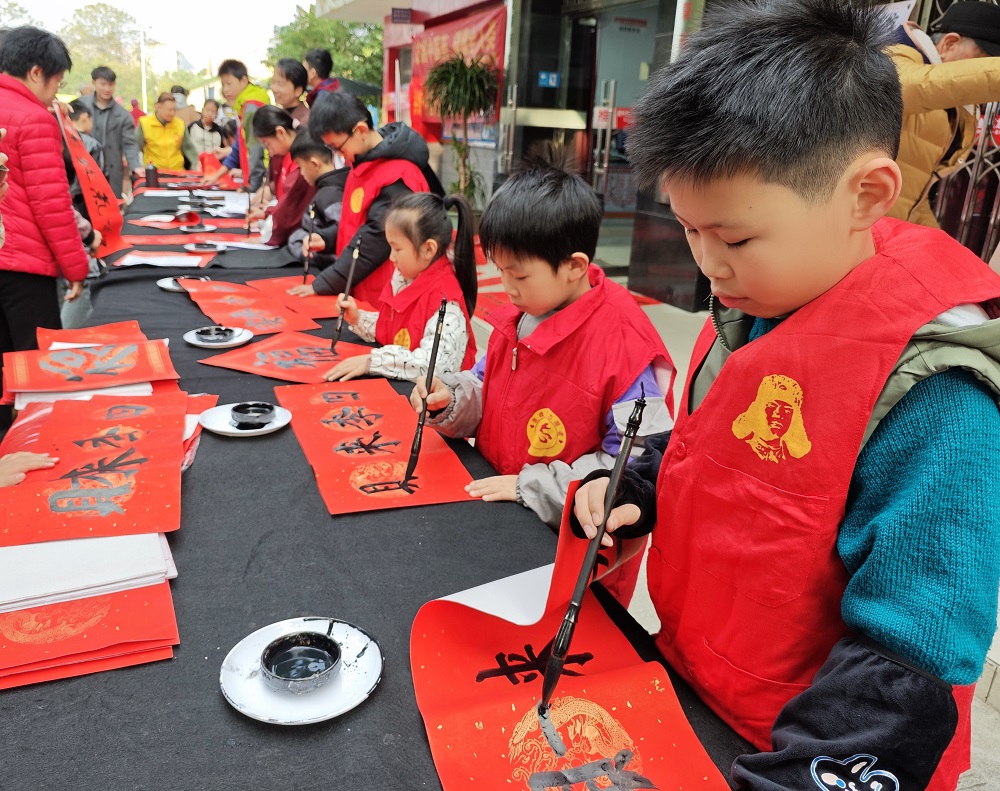 【龍擎苑社區(qū)年味濃！游園、市集、文藝匯演…居民家門口樂享新春】小志愿者們?yōu)檩爡^(qū)居民免費寫春聯(lián)送福1.jpg